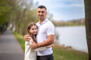 Baba kızını dışarıda kucaklıyor. aile portresi.