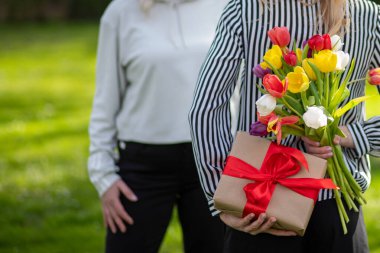 Kızı arkasında çiçekler ve gizli hediyelerle anneyi şaşırtıyor.