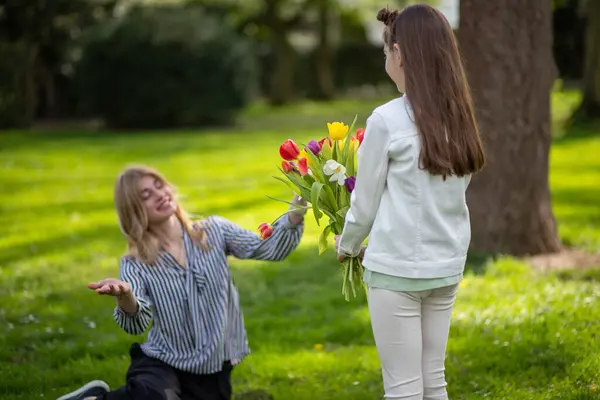 Anne laleleri hediye eden kız. Aile kutlaması, sevgi ve takdir.