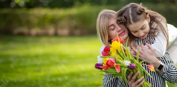 stock image Daughter hugging mother with tulips.