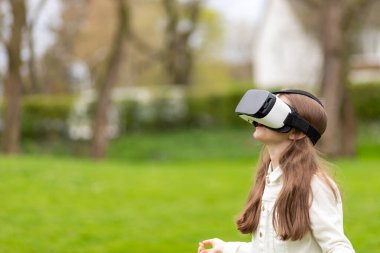 Sanal gerçeklik kulaklıklı kız parka bakıyor..