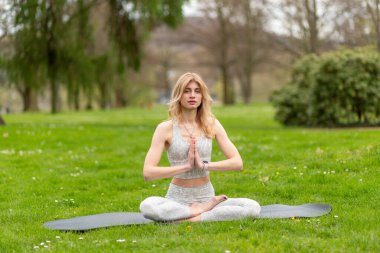 Lotustaki kadın parkta meditasyon yapıyor..