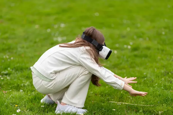 stock image Girl in virtual reality headset reaching out in a park.