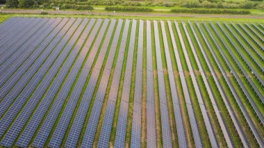 Yeşil bir alan üzerindeki güneş panellerinin havadan görüntüsü.