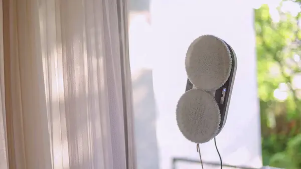 stock image Window cleaning robot with visible rotating brushes on glass