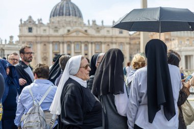 Vatikan - 23 Nisan 2025: Şemsiyeli rahibeler vedalaşma sırasında St. Peters 'de bekliyorlar.