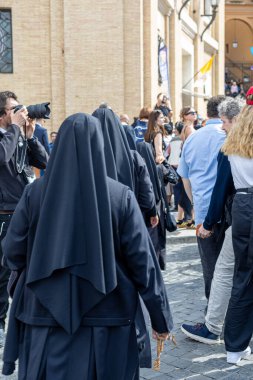 Vatikan - 23 Nisan 2025: Rahibeler hacılar ve fotoğrafçılarla kalabalığın arasında yürür.