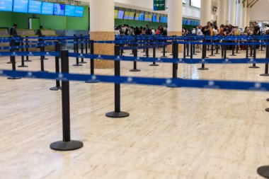 Punta Cana, Dominik Cumhuriyeti - Mart 27, 2025: Yoğun bir havaalanı terminalinde gezginler birden fazla kontrol gişesinde kuyruğa girdiler. İnsanlar yolculuklarına hazırlanırken atmosfer beklentiyle doludur..