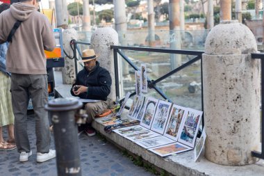 Rom, Italien - 22 Nisan 2025: Roma 'nın göbeğinde, kaldırımda yaşayan bir zanaatkar, ilginç bir ziyaretçinin dikkatini çekiyor..