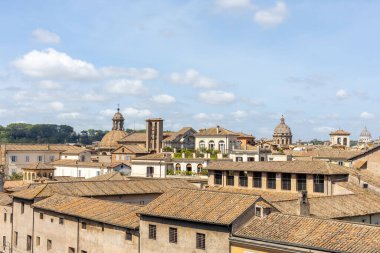 Nefes kesici bir manzara, açık mavi gökyüzünün altındaki tarihi bir İtalyan kasabasının büyüleyici çatılarını gözler önüne seriyor..