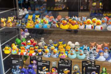 Rom, Italien - 23 Nisan 2025: Bir mağazanın raflarını dolduran canlı bir plastik ördek çeşidi. Farklı renkte ördekler, şekiller ve temalar müşterileri çeker, neşe ve nostalji getirir..