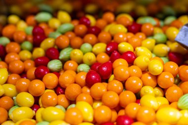 Çeşitli şeker şekilleri ve renklerden oluşan canlı bir düzenleme bir pazarda sergileniyor. Parlak sarılar, kırmızılar ve yeşiller şeker severler için mükemmel bir ortam yaratır..