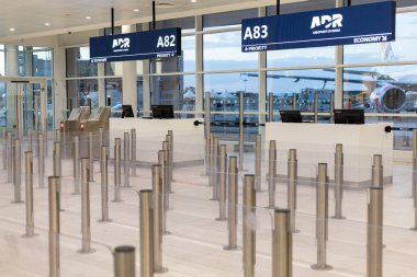 Fiumicino, Rom, Italien - 24 Nisan 2025: Havaalanındaki check-in alanı çeşitli uçuş sınıfları için boş gişeler gösteriyor. Sabahın erken saatlerinde az sayıda yolcunun bulunduğu atmosfer sakin..