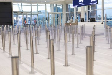 Fiumicino, Rom, Italien - 24 Nisan 2025: Kayıt alanı boş bilet gişelerine uzanan sayısız boş bariyer gösteriyor. Mekan aydınlık, sabah erken ya da akşam geç saatlerde havaalanında olduğunu gösteriyor..