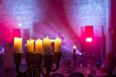 Yanıp sönen mumlar renkli ışıkların olduğu canlı bir etkinlikte sıcak bir parıltı sağlar. Konuklar çok güzel dekore edilmiş bir mekana karışıp şenlikli bir ortam yaratıyorlar..