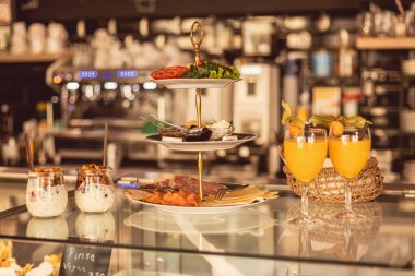 Lezzetli yemek katmanları cezbedici bir çay sergisi oluşturur. Sıcak bir kafe atmosferinde lezzetli atıştırmalıklar ve tatlı tatlılar ferahlatıcı içeceklerle güzelce düzenlenir..