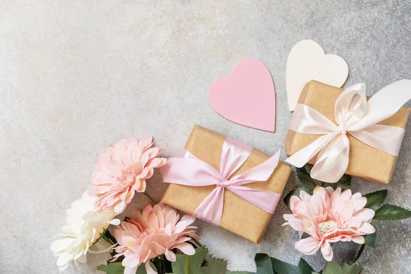 Valentine's Day background with gifts, beautiful flowers and hearts. Valentine's day, Womans day, wedding, birthday or mothers day greeting card. View from above. 