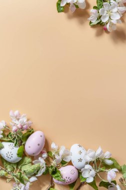 Happy Easter Holidays concept.  Easter eggs and apple tree flowers spring floral background. Spring Religious holiday Easter. View from above. 