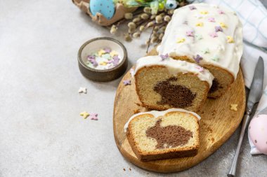Happy Easter holiday food baking, cupcake with Easter Bunny and colorful eggs on stone background. Copy space.