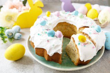 Şekerlemelerle süslenmiş paskalya limonlu pasta ve gri taşlı arka planda mini çikolatalı yumurta şekeri. Mutlu Paskalyalar, lezzetli tatlı.