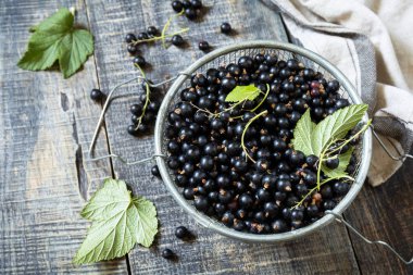 Çiğ organik meyveler. C vitamini konsepti. Köy tarzında taze siyah üzümler ahşap bir masada..