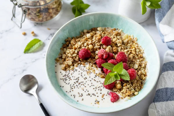 Kahvaltı, tatlı tatlı. Diyet beslenme konsepti. Ev yapımı granola yoğurt, chia tohumu ve ahududu mermer bir masanın üstünde..