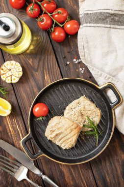 Restoran yemeği. Deniz ürünleri. Kırsal tarzda. Baharatlı, domatesli ve biberiyeli sulu ton balığı bifteği.. 