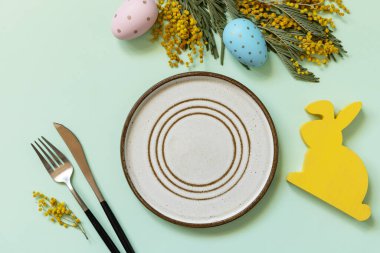 Paskalya sofrası. Pastel yeşil arka planda paskalya yumurtası ve mimoza tabağı. Restoranlar için iyi Paskalya tatili konseptleri. Yukarıdan görüntüle. 