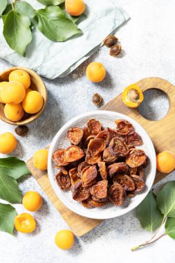 Kurutulmuş meyve. Gri bir arka planda kurumuş kayısılar ve çiğ kayısılar. Yukarıdan görüntüle. 