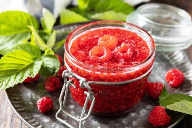 Ev yapımı koruma. Lezzetli ahududu reçeli veya ahşap bir masada reçel. 