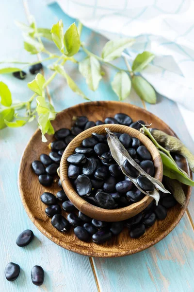 有機野菜の生 ビーガンやダイエット食品の概念 木のテーブルの上に新鮮な熟した黒豆 — ストック写真