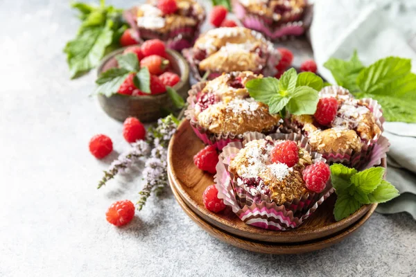 Healthy dessert. Vegan gluten-free pastry. Oatmeal banana muffins with raspberry and coconut flakes on a stone table. Copy space.