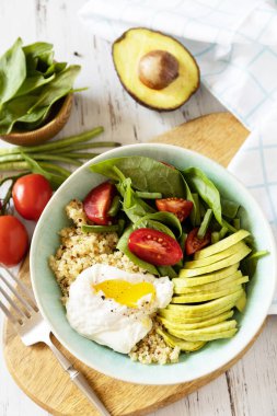 Lezzetli kahvaltı ya da brunch - haşlanmış yumurta, kinoa, avokado ve mutfak masasında taze sebze salatası. Keto diyeti.