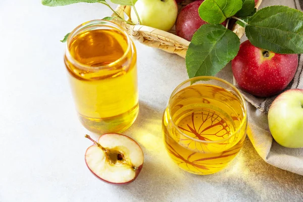 Apple juice in a glass and fresh apples on a stone tabetop. Autumn vitamin drink juice apple. Copy space.