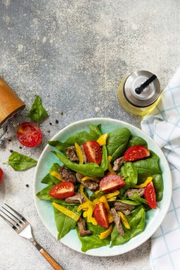 Ispanak salatası, tavuk ciğeri, domates ve baharatlı ızgara biber ve balzamik. Sağlıklı keto diyeti düşük karbonhidrat. Yukarıdan bak. Boşluğu kopyala.