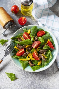 Ispanak salatası, tavuk ciğeri, domates ve baharatlı ızgara biber ve balzamik. Sağlıklı keto diyeti düşük karbonhidrat. Boşluğu kopyala.