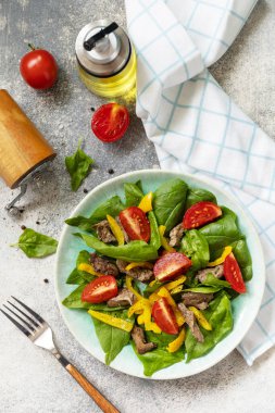 Ispanak salatası, tavuk ciğeri, domates ve baharatlı ızgara biber ve balzamik. Sağlıklı keto diyeti düşük karbonhidrat. Yukarıdan görüntüle. 