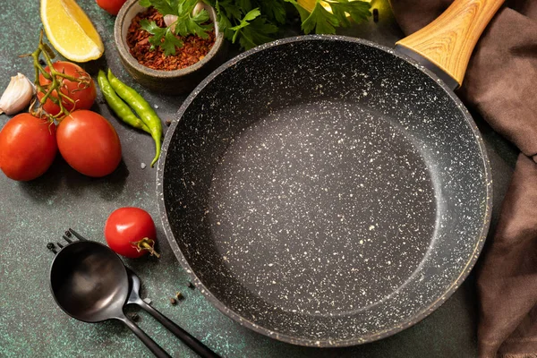 stock image Food cooking background with Frying pan. Empty skillet, vegetables, spices and herbs on dark table background.