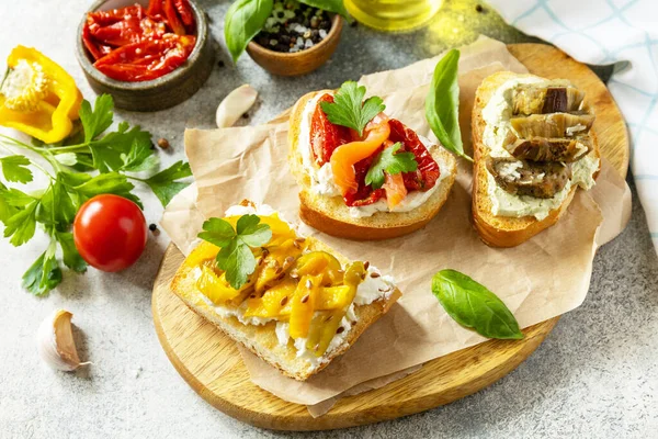 塩鮭とオープンサンドイッチセット 太陽乾燥トマト オーベルギネをグリル 石のテーブルの上にブルガリアコショウとクリームチーズをグリル 健康食品 ベジタリアン前菜 — ストック写真