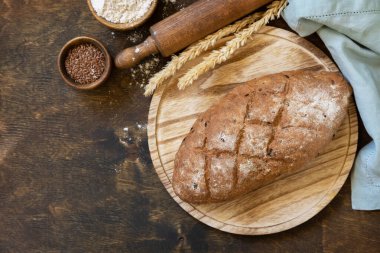 Ev yapımı pişirme. Tam buğday tanelerinden ekmek, buğday kepeği, tohumlar, kırsal masa altyapısı üzerinden biyolojik malzemeler, sağlıklı yaşam tarzı. Yukarıdan görüntüle.