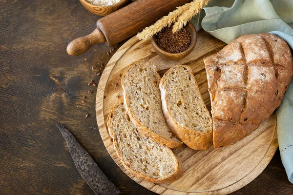 Bread from whole wheat grains, wheat bran, seeds, bio-ingredients over rustic table background. Homemade baking,  healthy lifestyle.. Copy space.