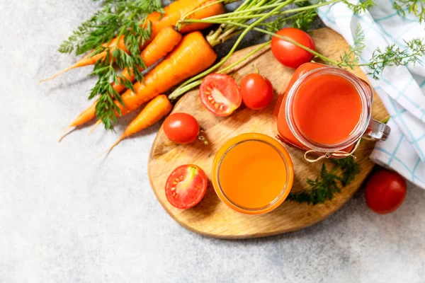 番茄和胡萝卜汁放在石桌上的杯子里 维生素喝果汁 胡萝卜和西红柿 健康的生活方式从上面看复制空间 — 图库照片