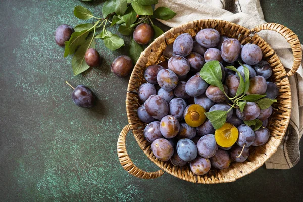 stock image Fruit background, organic fruits. Still life food. Basket of fresh blue plums on a stone table. View from above. Copy space.