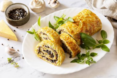 Vejetaryen lezzetli yemekler. Mermer bir masanın üstünde peynir ve mantarlı kabak rulosu (roulade). 