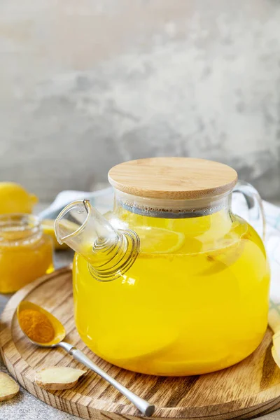 Antioxidant ginger turmeric lemon tea with honey on a stone table. Healthy organic vegan drink. Winter tea, Immunity boosting drink. Copy space.