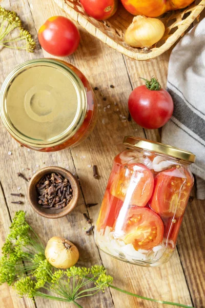 Healthy homemade fermented food. Salted pickled tomatoes and onions preserved canned in glass jar. Home economics, autumn harvest preservation. View from above.