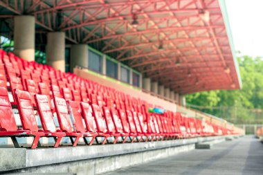 Futbol maçını neşelendirmek için stadyumdaki boş kırmızı plastik sandalyeler.
