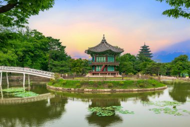 Güney Kore, Seul 'deki Gyeongbokgung Sarayı' ndaki göletin ortasındaki Hyangwonjeong Pavyonu 'nda gün batımı..