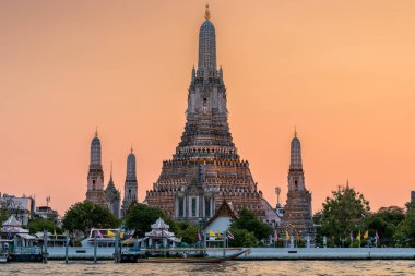 Wat Arun stupa, ya da Şafak Tapınağı, Tayland, Bangkok 'un önemli bir simgesidir, Chao Phraya nehri boyunca güzel turuncu bir gün batımı gökyüzü ile göze çarpar..