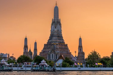 Wat Arun stupa, ya da Şafak Tapınağı, Tayland, Bangkok 'un önemli bir simgesidir, Chao Phraya nehri boyunca güzel turuncu bir gün batımı gökyüzü ile göze çarpar..
